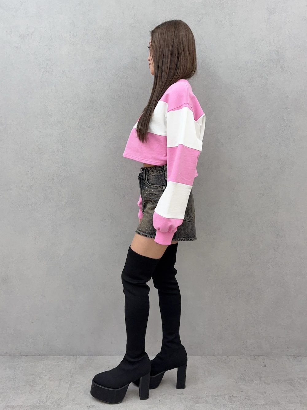 ブルー系のデニムスカート、ブラック系のブーツ、ピンク系のTシャツ/カットソーを着用したレディースの冬コーディネートの2枚目の写真