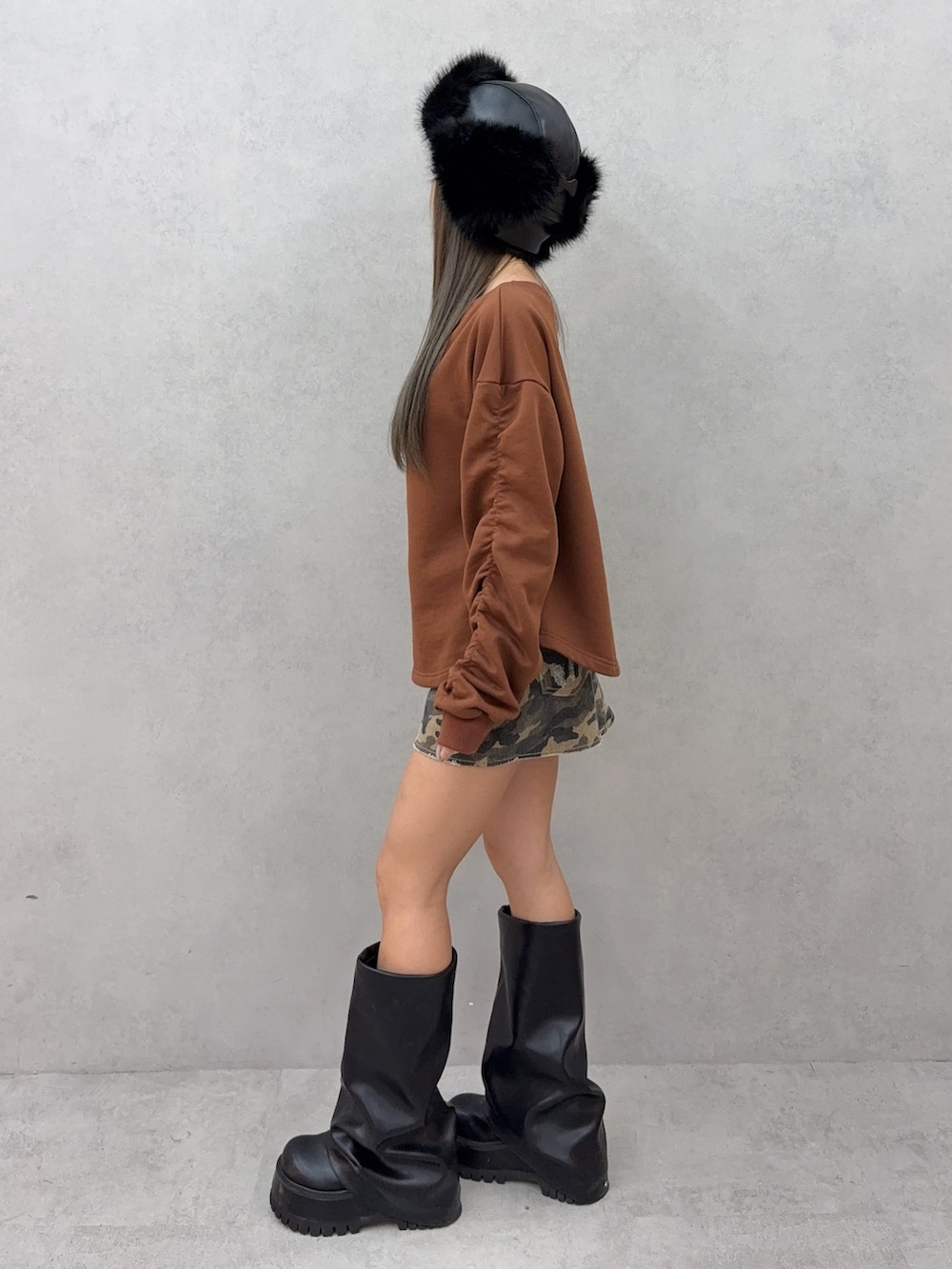 ブラウン系のスウェット、その他のデニムスカート、ブラック系のブーツを着用したレディースの秋コーディネートの2枚目の写真