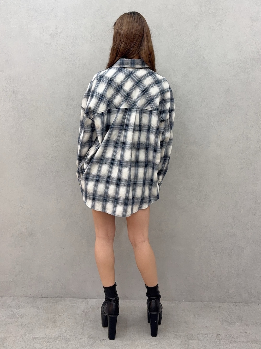 ブルー系のシャツ/ブラウス、ブラック系のデニムスカート、ブラック系のブーツを着用したレディースの春コーディネートの3枚目の写真