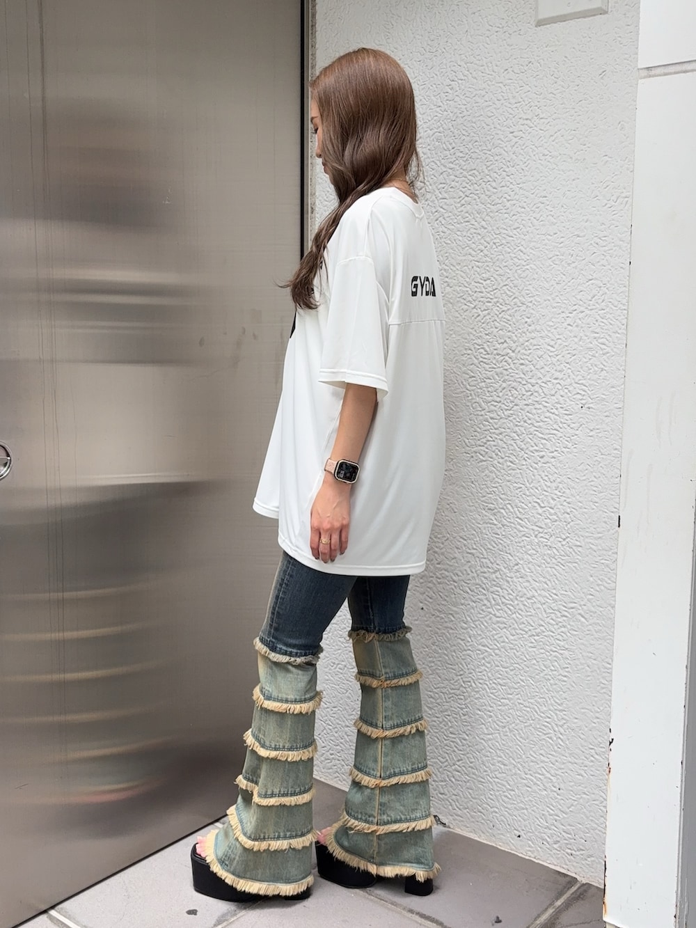 ホワイト系のTシャツ/カットソー、ブルー系のデニムパンツ、ブラック系のサンダルを着用したレディースの夏コーディネートの2枚目の写真