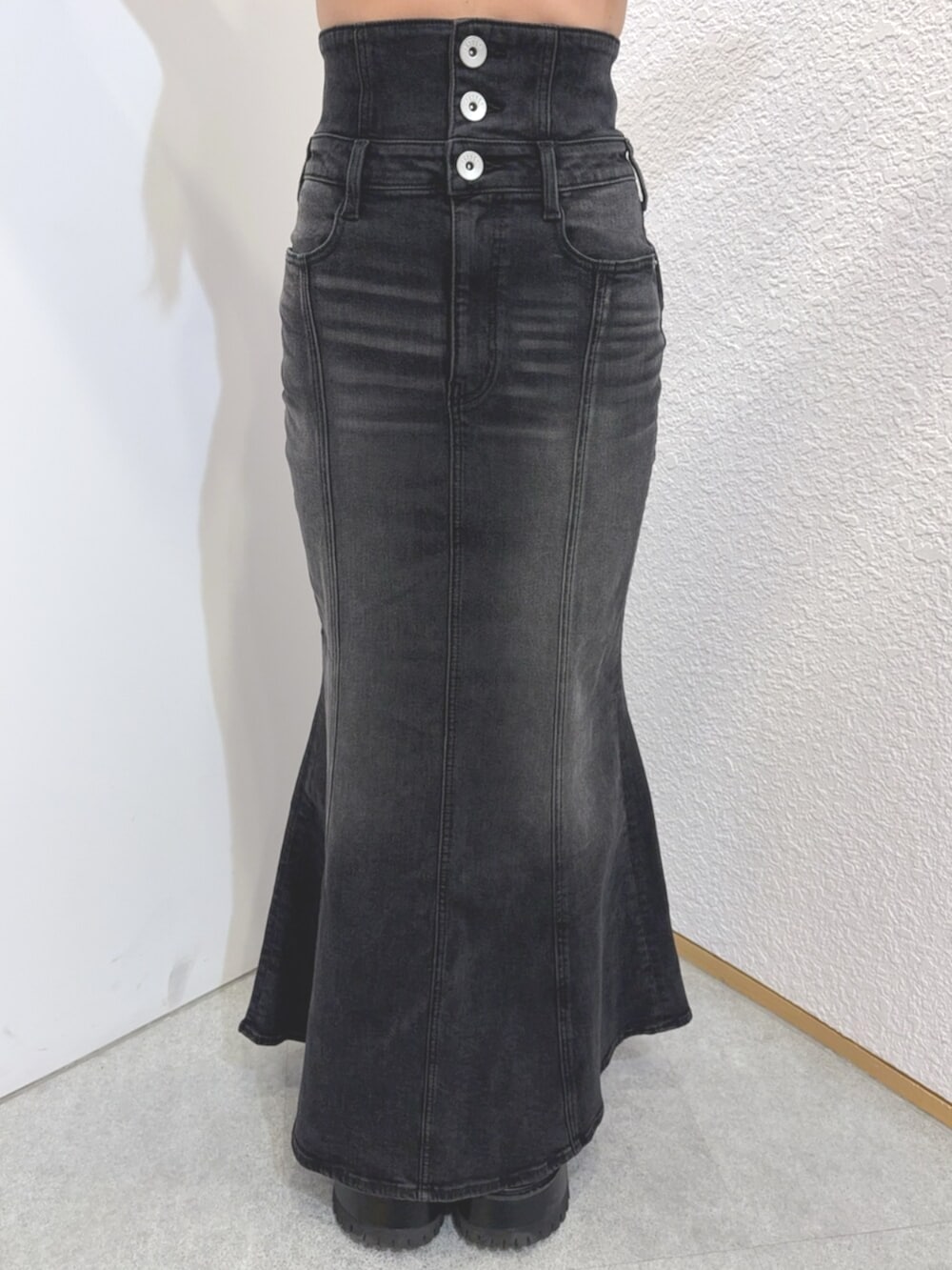 ブラック系のブーツ、レッド系のニット/セーター、ブラック系のデニムスカートを着用したレディースの秋コーディネートの5枚目の写真