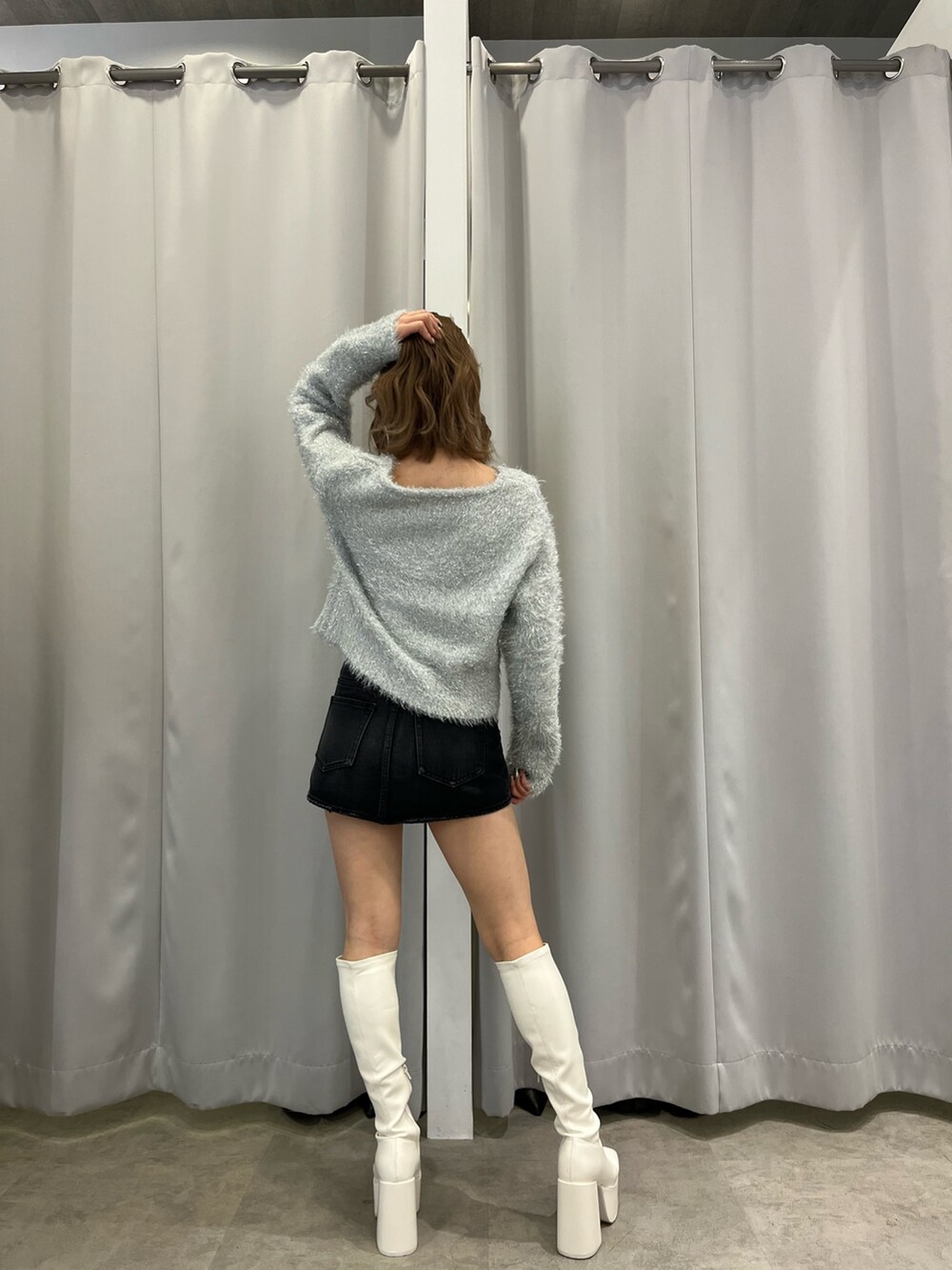 ホワイト系のダウンジャケット/コート、グレー系のニット/セーター、ブラック系のデニムスカートを着用したレディースの冬コーディネートの3枚目の写真