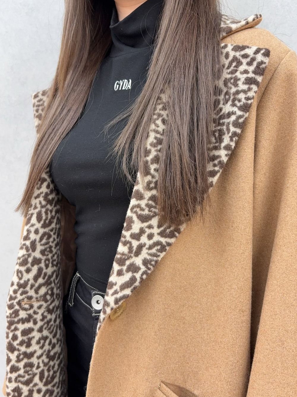 イエロー系のダウンジャケット/コート、ブラック系のブーツ、ブラック系のデニムパンツを着用したレディースの冬コーディネートの4枚目の写真