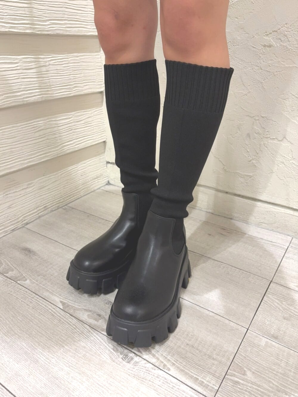 ブルー系のデニムスカート、ブラック系のブーツ、ベージュ系のニット/セーターを着用したレディースの秋コーディネートの6枚目の写真