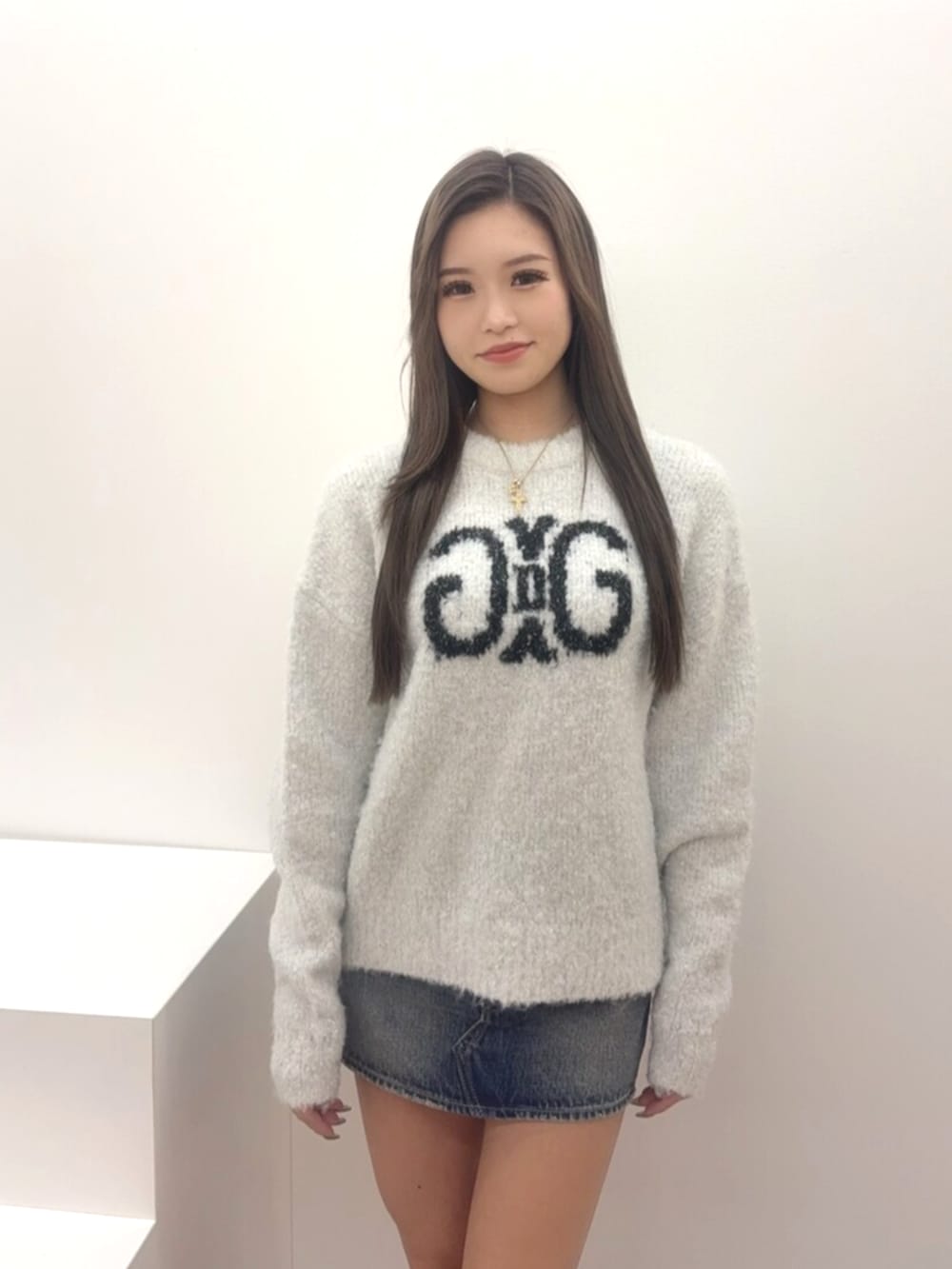 ベージュ系のブーツ、ブルー系のデニムスカート、ホワイト系のニット/セーターを着用したレディースの冬コーディネートの4枚目の写真