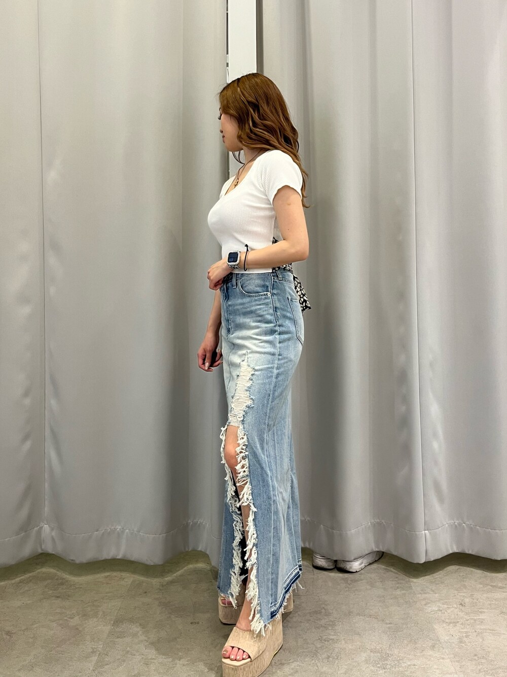 ホワイト系のTシャツ/カットソー、ブルー系のデニムスカート、ホワイト系のサンダルを着用したレディースの夏コーディネートの2枚目の写真