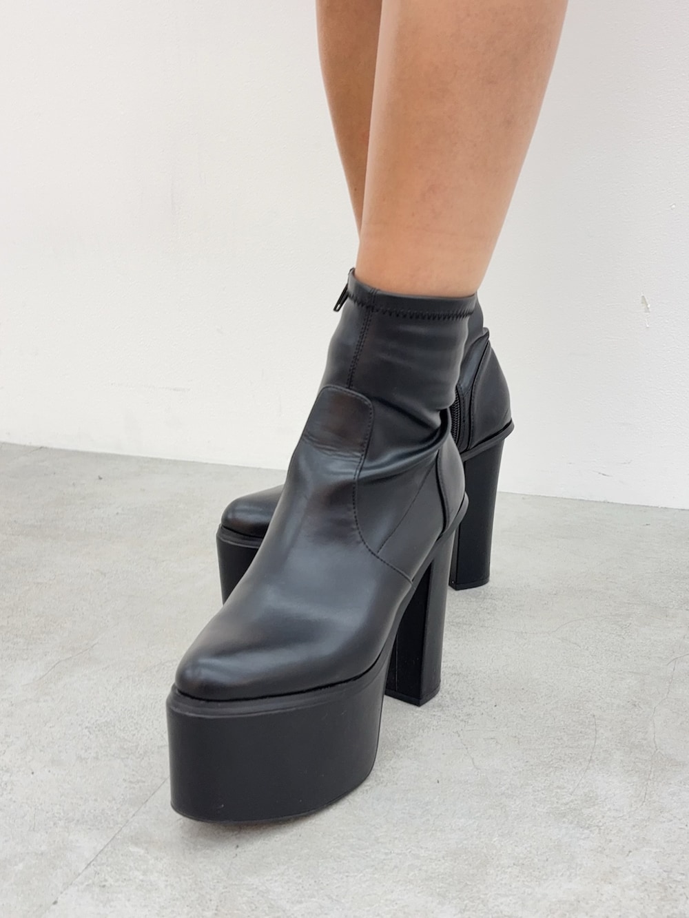 オレンジ系のニット/セーター、ブルー系のデニムスカート、ブラック系のブーツを着用したレディースの秋コーディネートの5枚目の写真