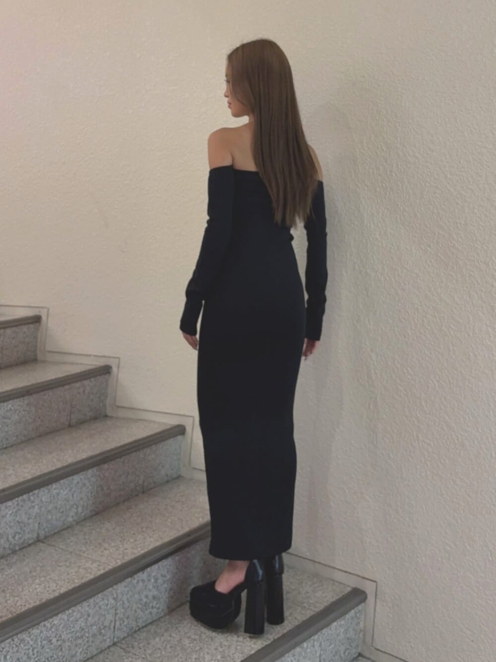 ブラック系のワンピース、ブラック系のパンプスを着用したレディースの秋コーディネートの3枚目の写真