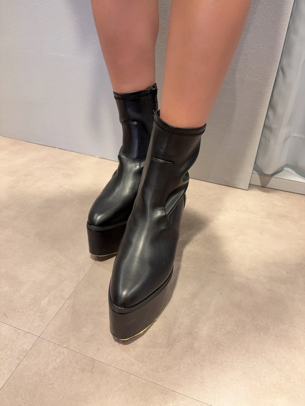 ブラック系のニット/セーター、ブルー系のデニムパンツ、ブラック系のブーツを着用したレディースの秋コーディネートの5枚目の写真