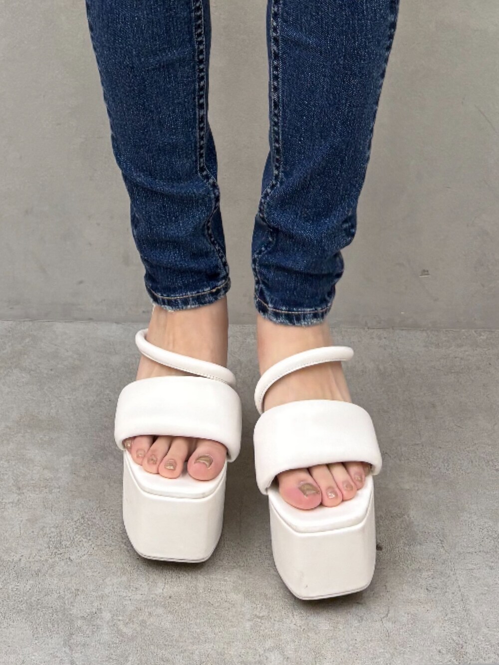 ホワイト系のニット/セーター、ブルー系のデニムパンツ、ホワイト系のサンダルを着用したレディースの夏コーディネートの7枚目の写真
