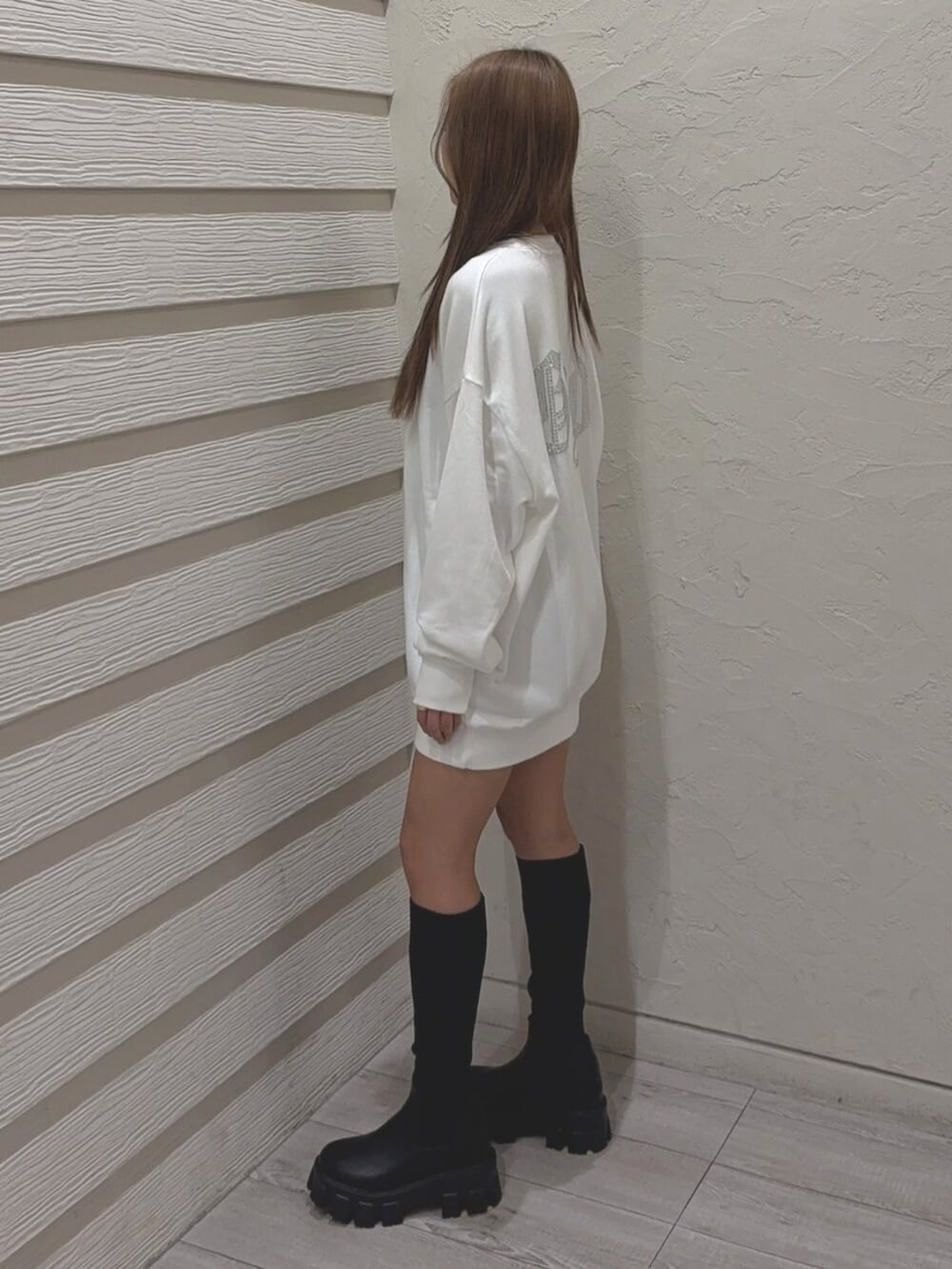 ブラック系のブーツ、ホワイト系のパーカーを着用したレディースの秋コーディネートの2枚目の写真