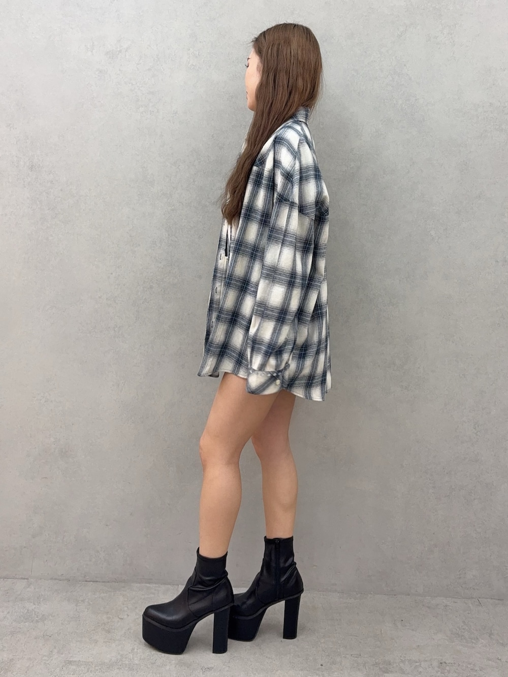 ブルー系のシャツ/ブラウス、ブラック系のデニムスカート、ブラック系のブーツを着用したレディースの春コーディネートの2枚目の写真