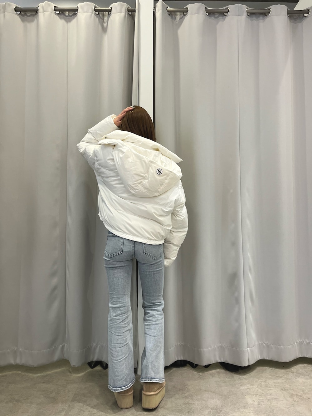 ホワイト系のダウンジャケット/コート、ベージュ系のニット/セーター、ブルー系のデニムパンツを着用したレディースの冬コーディネートの2枚目の写真