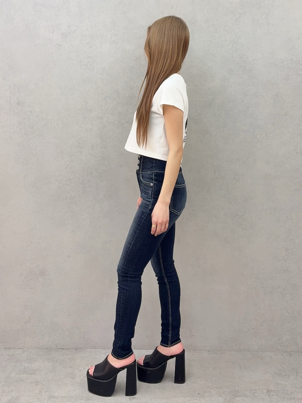 ブルー系のデニムパンツ、ブラック系のサンダル、ホワイト系のTシャツ/カットソーを着用したレディースの春コーディネートの2枚目の写真