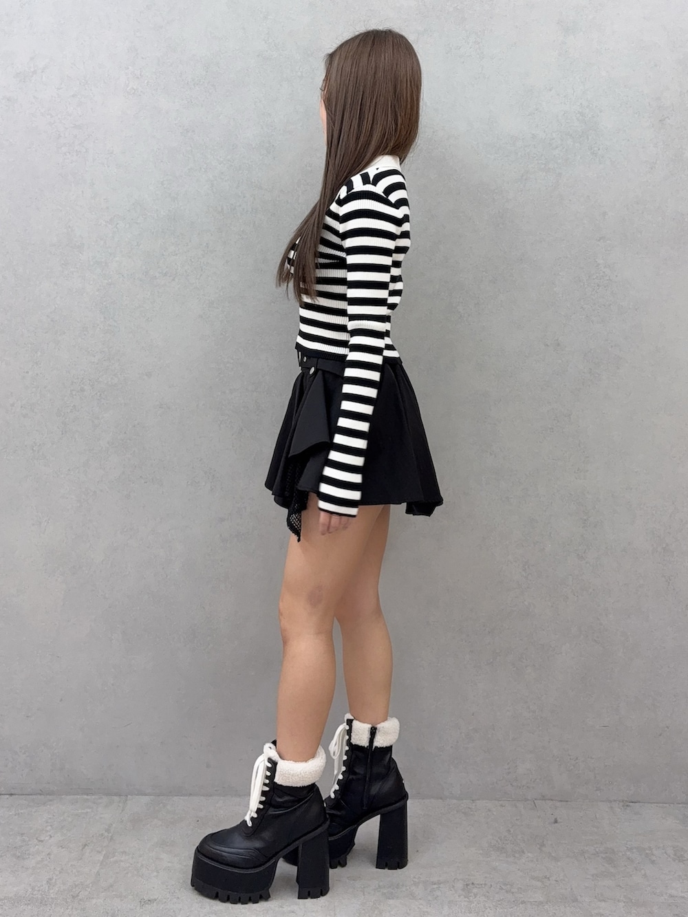 その他のニット/セーター、ブラック系のスカート、ブラック系のブーツを着用したレディースの冬コーディネートの2枚目の写真