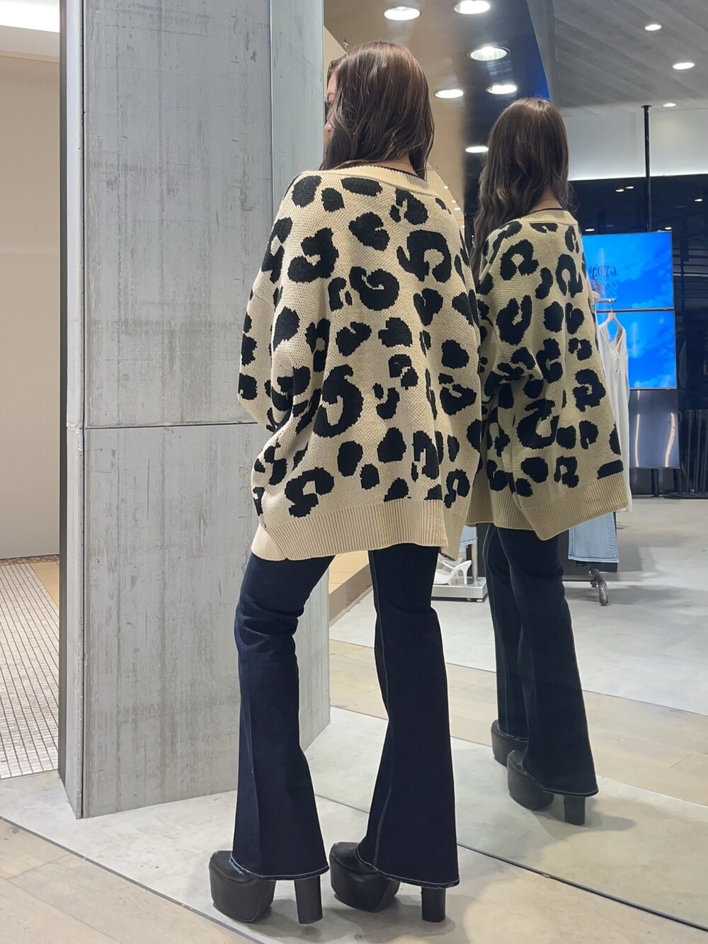 ブラック系のキャミソール、ブルー系のデニムパンツ、ブラック系のブーツを着用したレディースの春コーディネートの2枚目の写真