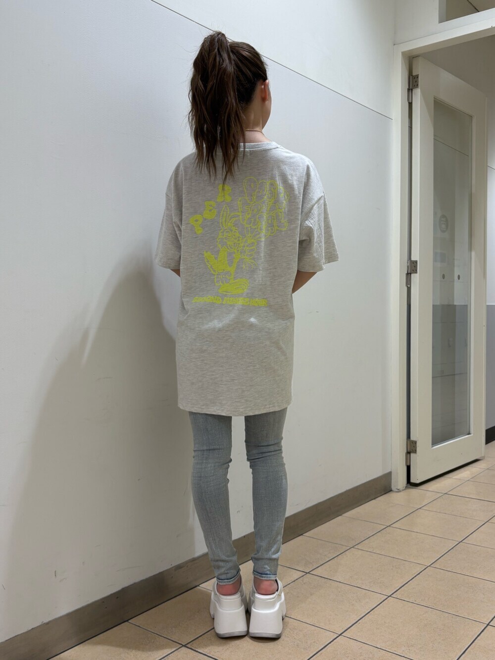 ホワイト系のサンダル、ブルー系のデニムパンツ、グレー系のTシャツ/カットソーを着用したレディースの春コーディネートの3枚目の写真