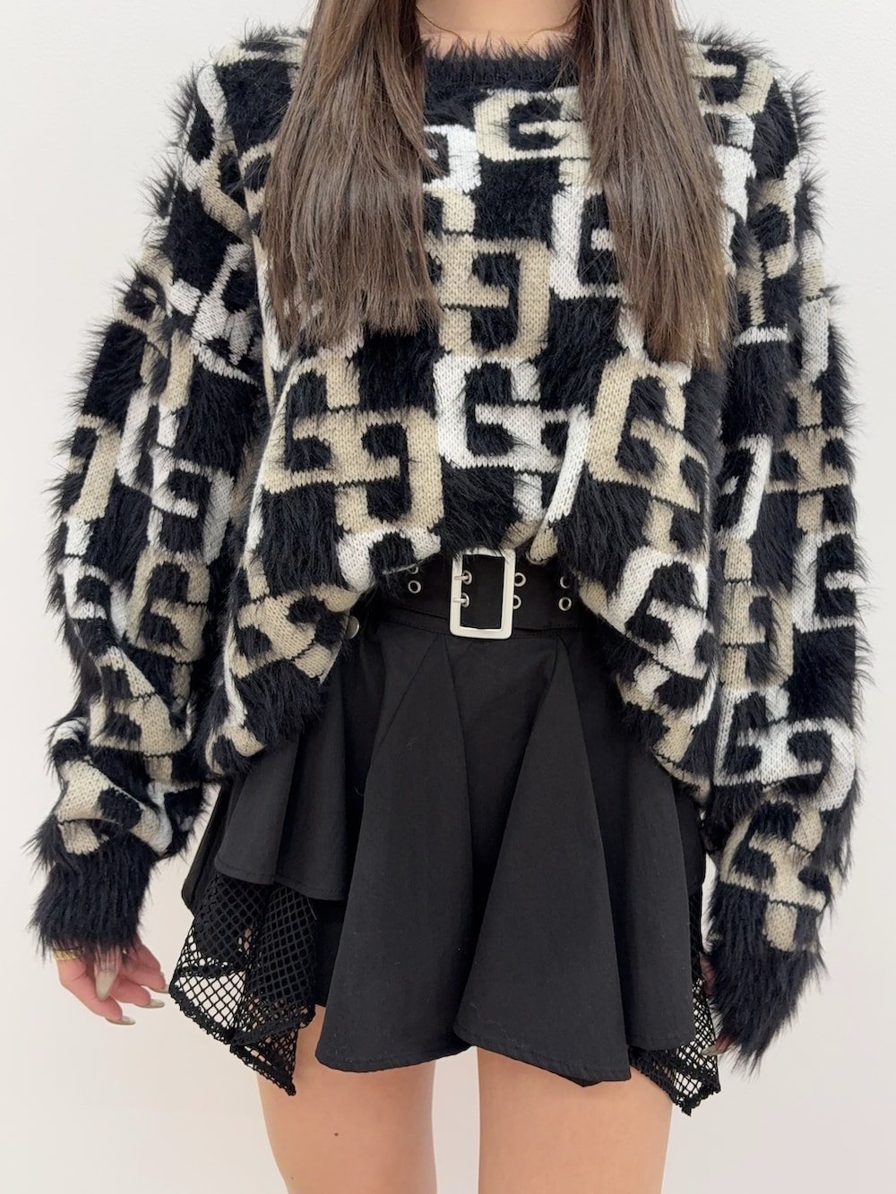 ブラック系のニット/セーター、ブラック系のブーツ、ブラック系のスカートを着用したレディースの冬コーディネートの4枚目の写真