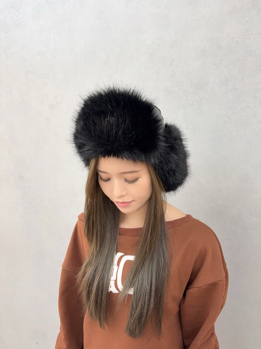 ブラウン系のスウェット、その他のデニムスカート、ブラック系のブーツを着用したレディースの秋コーディネートの4枚目の写真