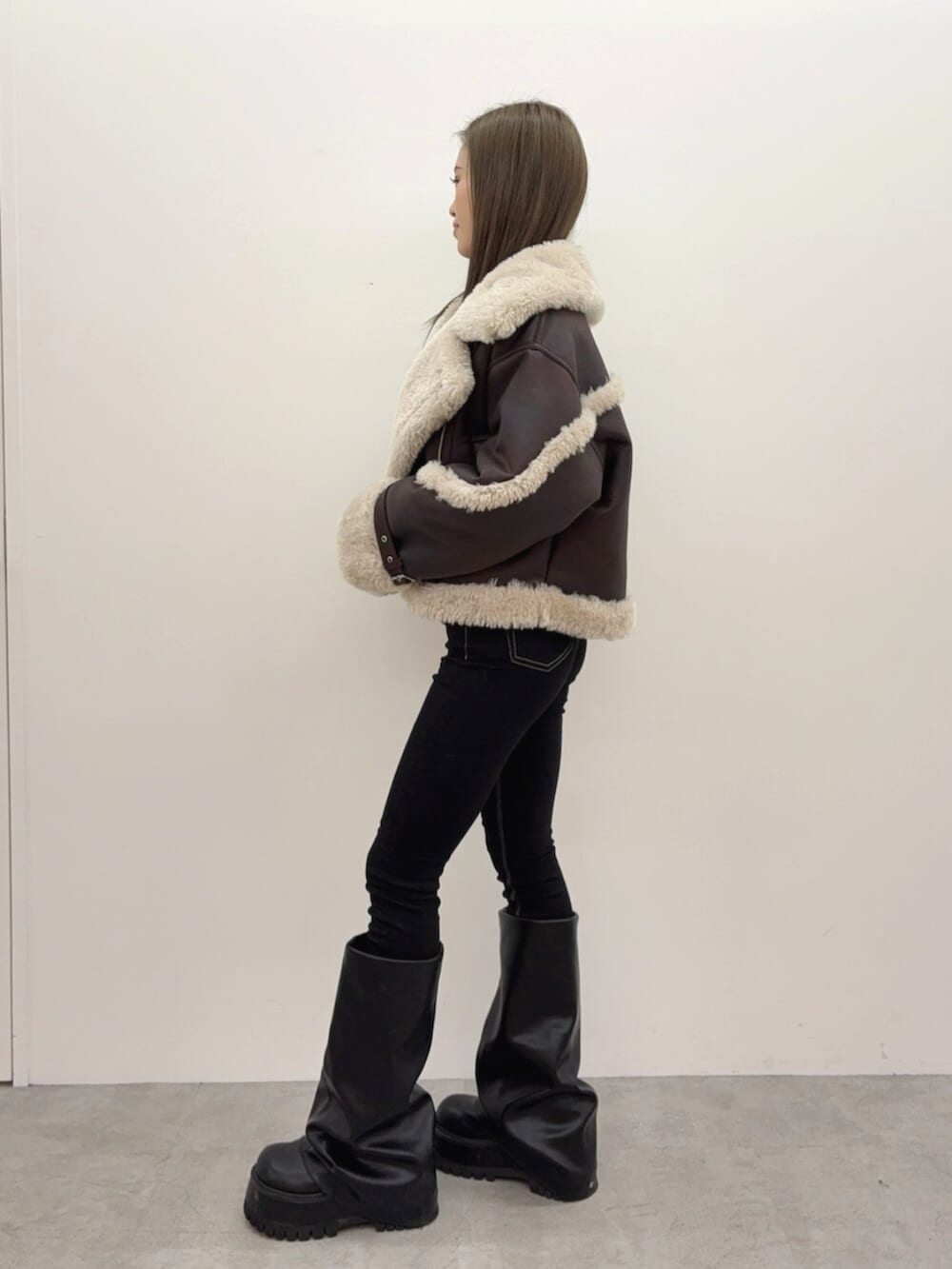 ブラック系のブーツ、ブラック系のデニムパンツ、ブラック系のTシャツ/カットソーを着用したレディースの秋コーディネートの2枚目の写真