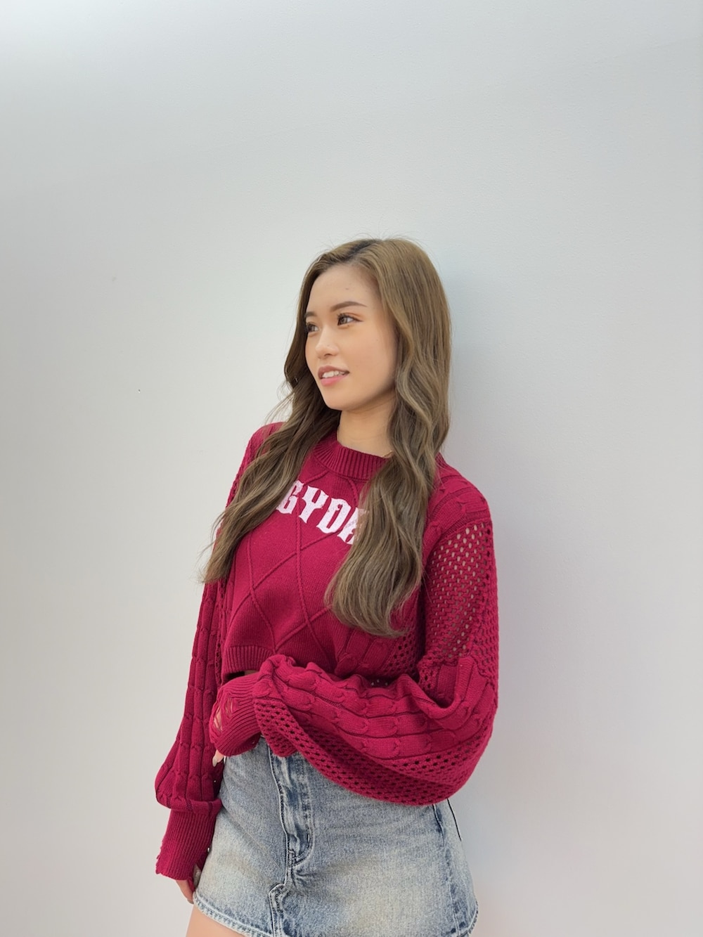 ブラック系のブーツ、ブルー系のデニムスカート、レッド系のニット/セーターを着用したレディースの夏コーディネートの4枚目の写真