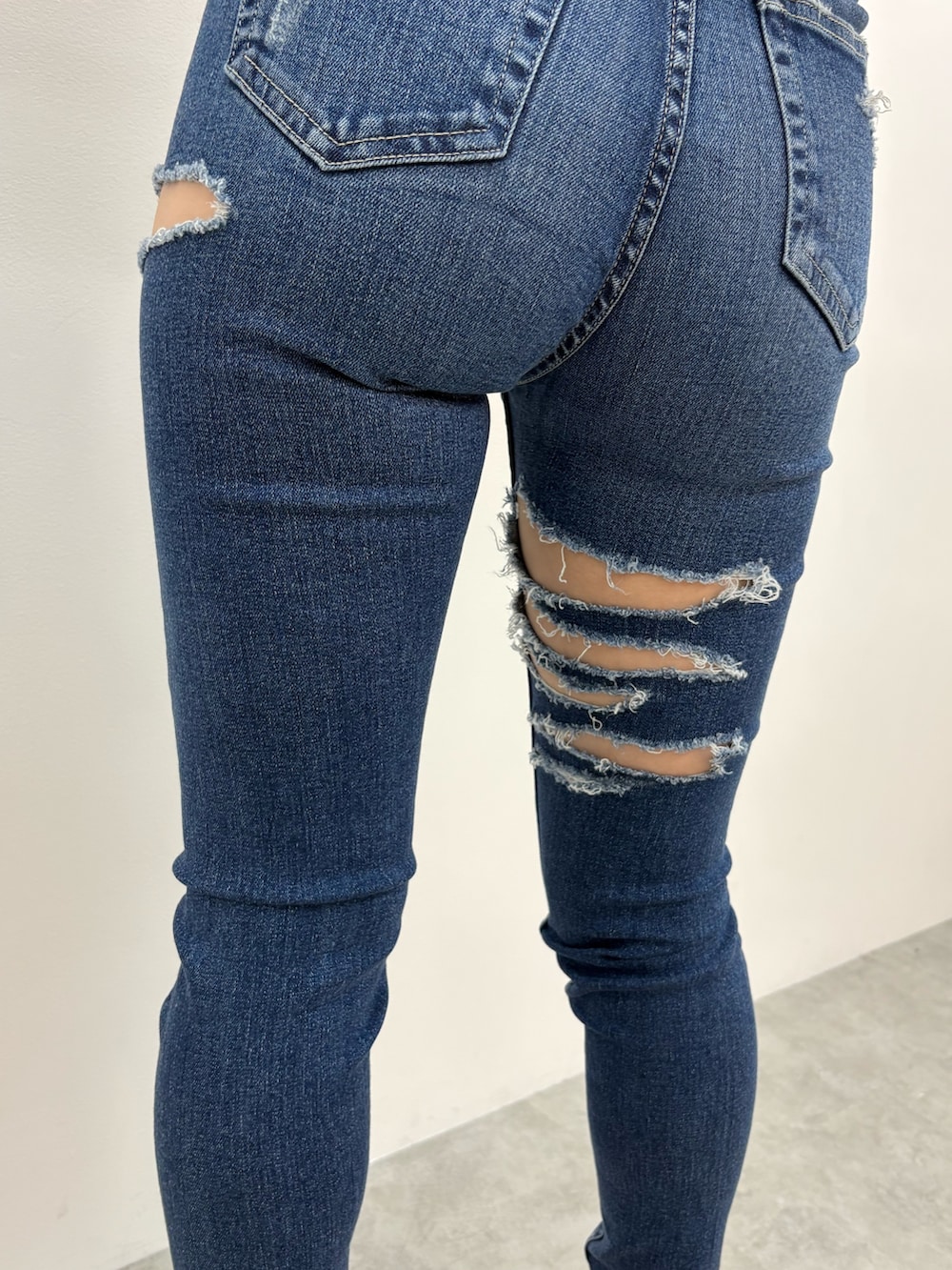 ブラック系のニット/セーター、ブルー系のデニムパンツ、ブラック系のサンダルを着用したレディースの夏コーディネートの6枚目の写真
