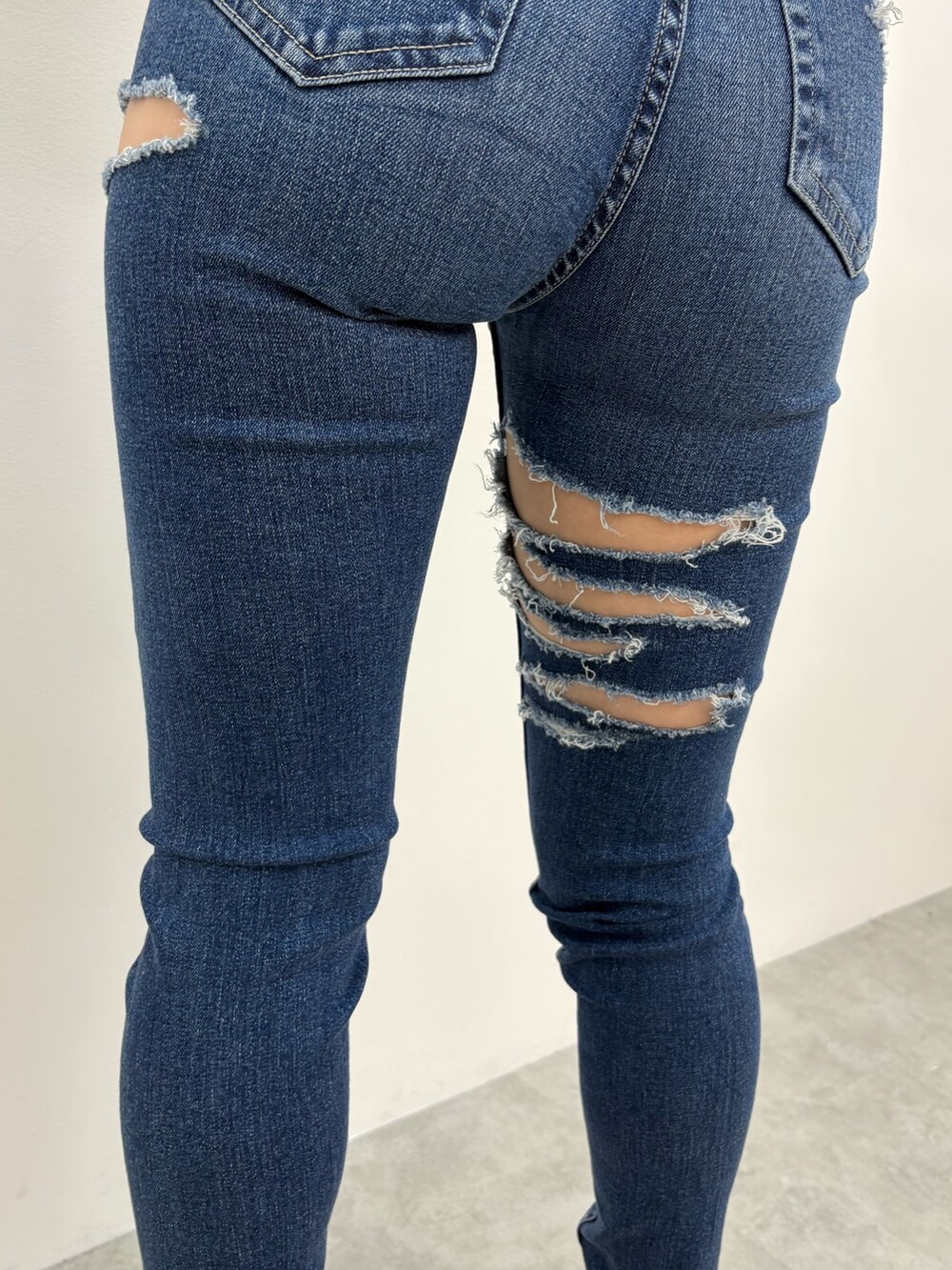 ホワイト系のニット/セーター、ブルー系のデニムパンツ、ホワイト系のサンダルを着用したレディースの夏コーディネートの6枚目の写真