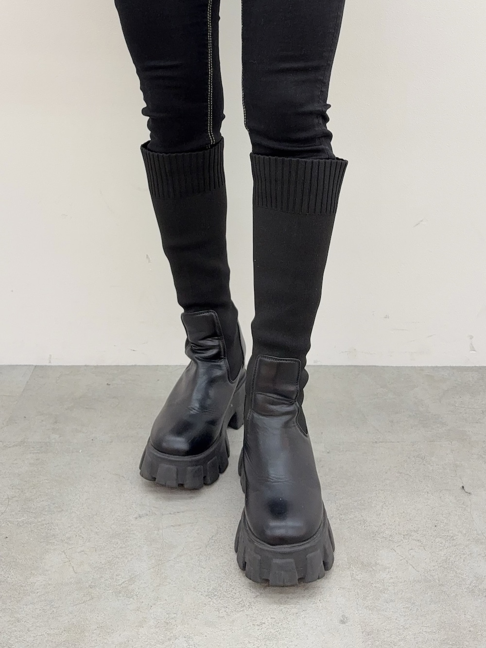 ブラック系のデニムパンツ、ブラック系のブーツ、ブラック系のニット/セーターを着用したレディースの秋コーディネートの5枚目の写真