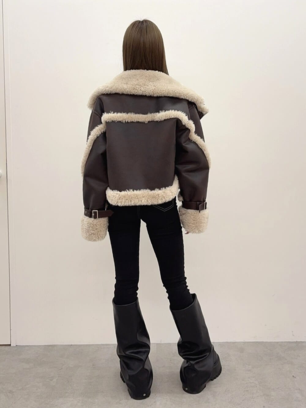 ブラック系のブーツ、ブラック系のデニムパンツ、ブラック系のTシャツ/カットソーを着用したレディースの秋コーディネートの3枚目の写真