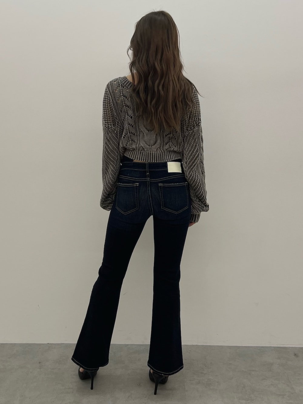 ブルー系のニット/セーター、ブルー系のデニムパンツ、ブラック系のパンプスを着用したレディースの春コーディネートの3枚目の写真