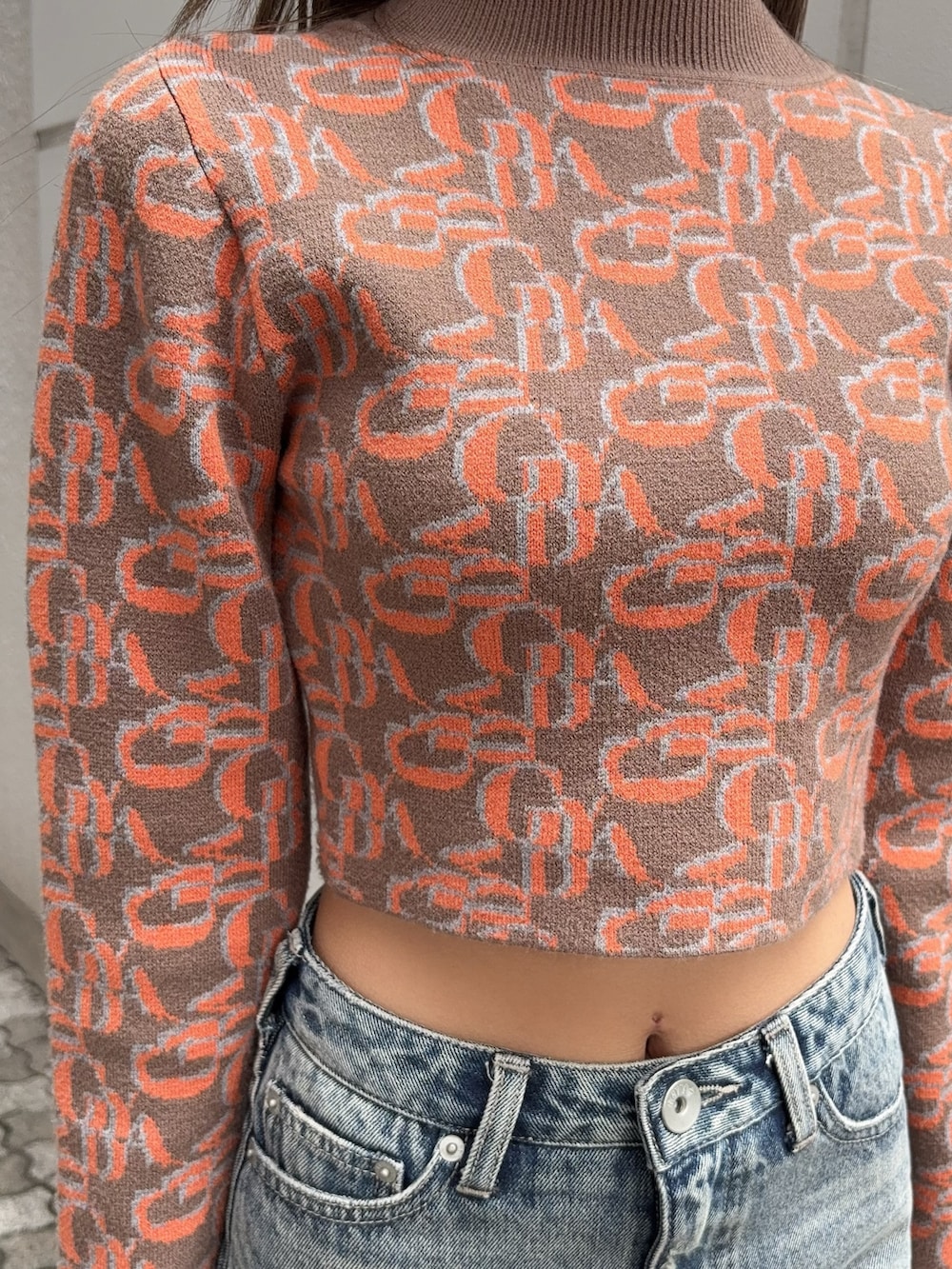 オレンジ系のニット/セーター、ブルー系のデニムスカート、ブラック系のブーツを着用したレディースの秋コーディネートの4枚目の写真