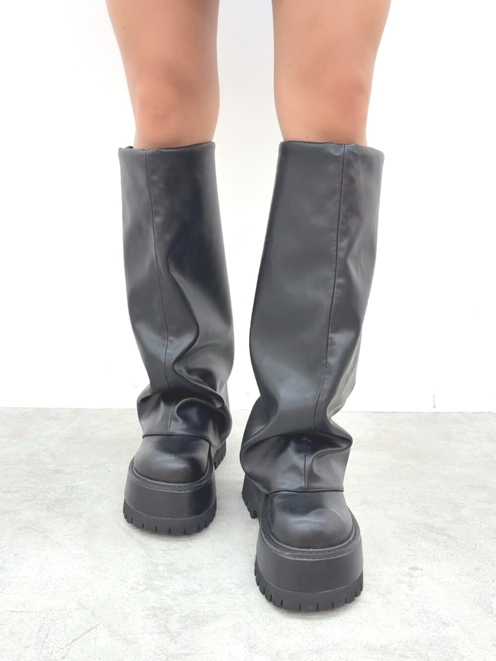 ブラック系のブーツ、レッド系のニット/セーター、ブラック系のデニムスカートを着用したレディースの秋コーディネートの7枚目の写真