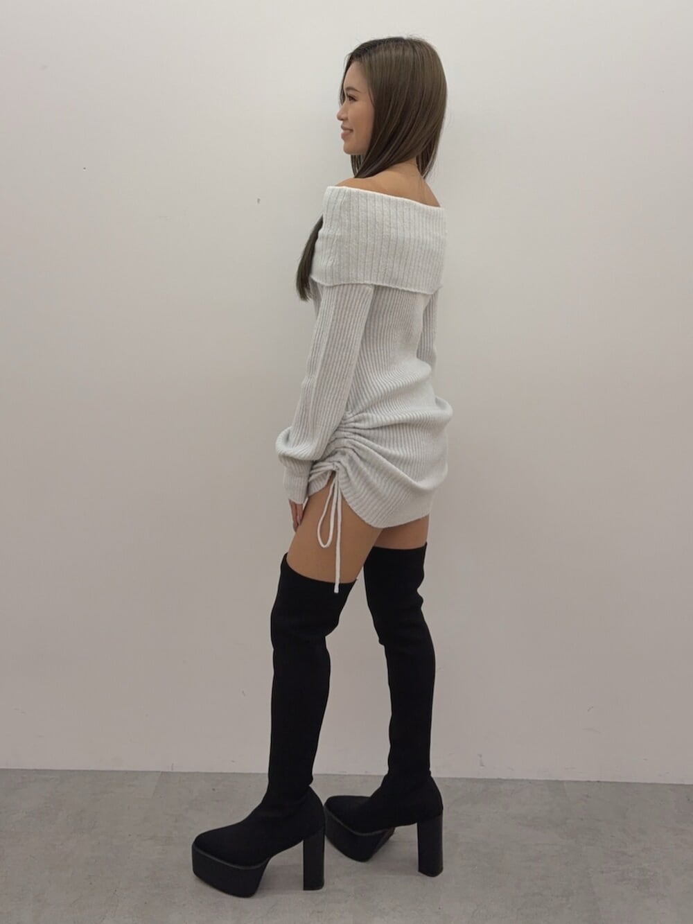 ホワイト系のチュニック、ブラック系のブーツを着用したレディースの秋コーディネートの2枚目の写真