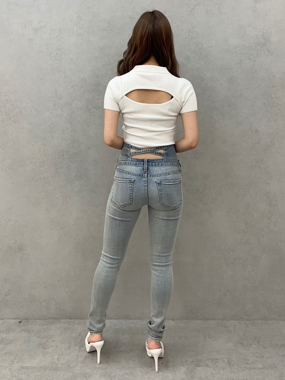 ホワイト系のニット/セーター、ブルー系のデニムパンツ、ホワイト系のパンプスを着用したレディースの春コーディネートの3枚目の写真