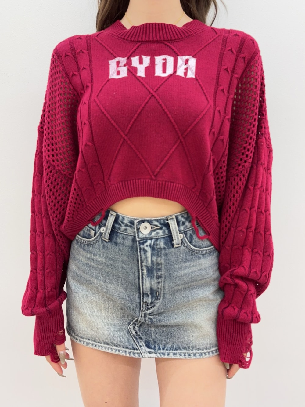 ブラック系のブーツ、ブルー系のデニムスカート、レッド系のニット/セーターを着用したレディースの夏コーディネートの5枚目の写真