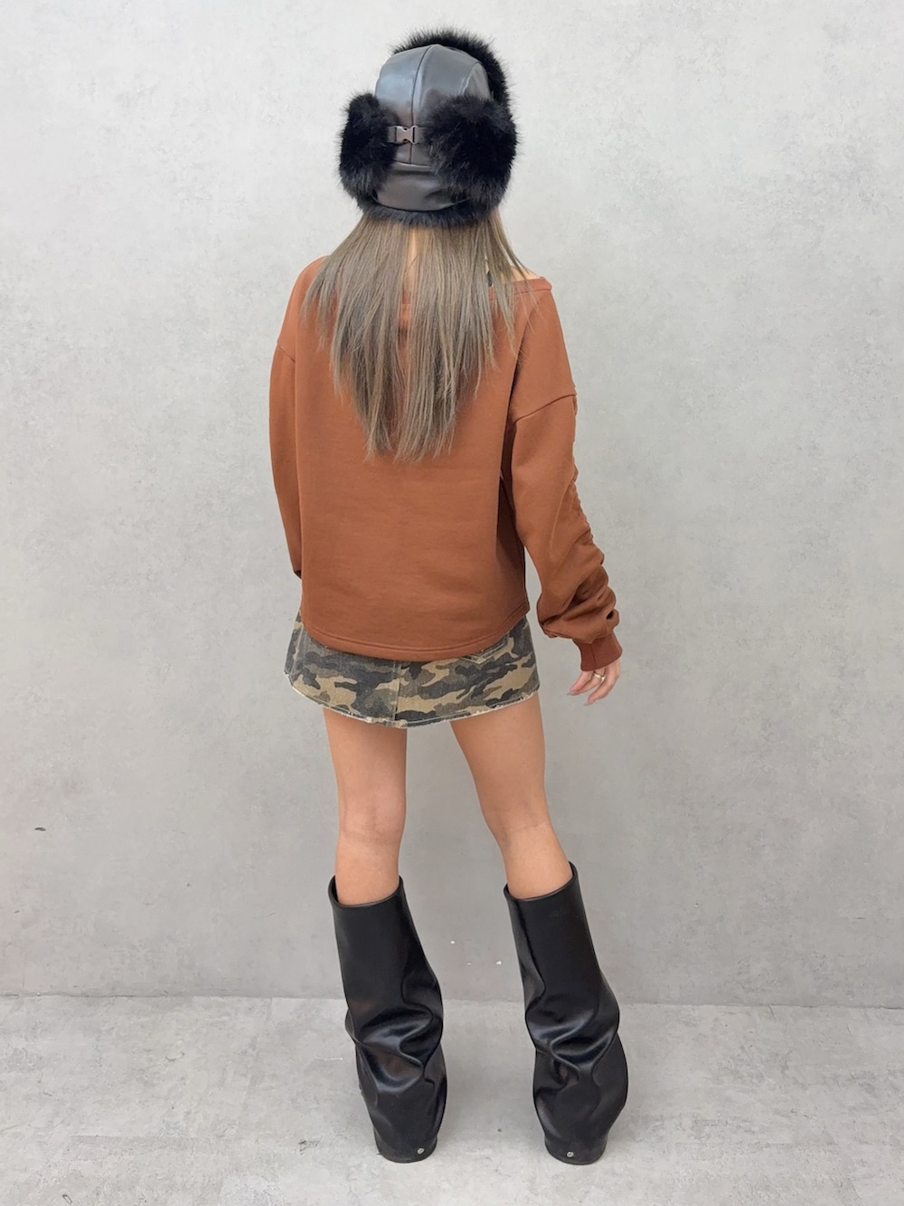 ブラウン系のスウェット、その他のデニムスカート、ブラック系のブーツを着用したレディースの秋コーディネートの3枚目の写真