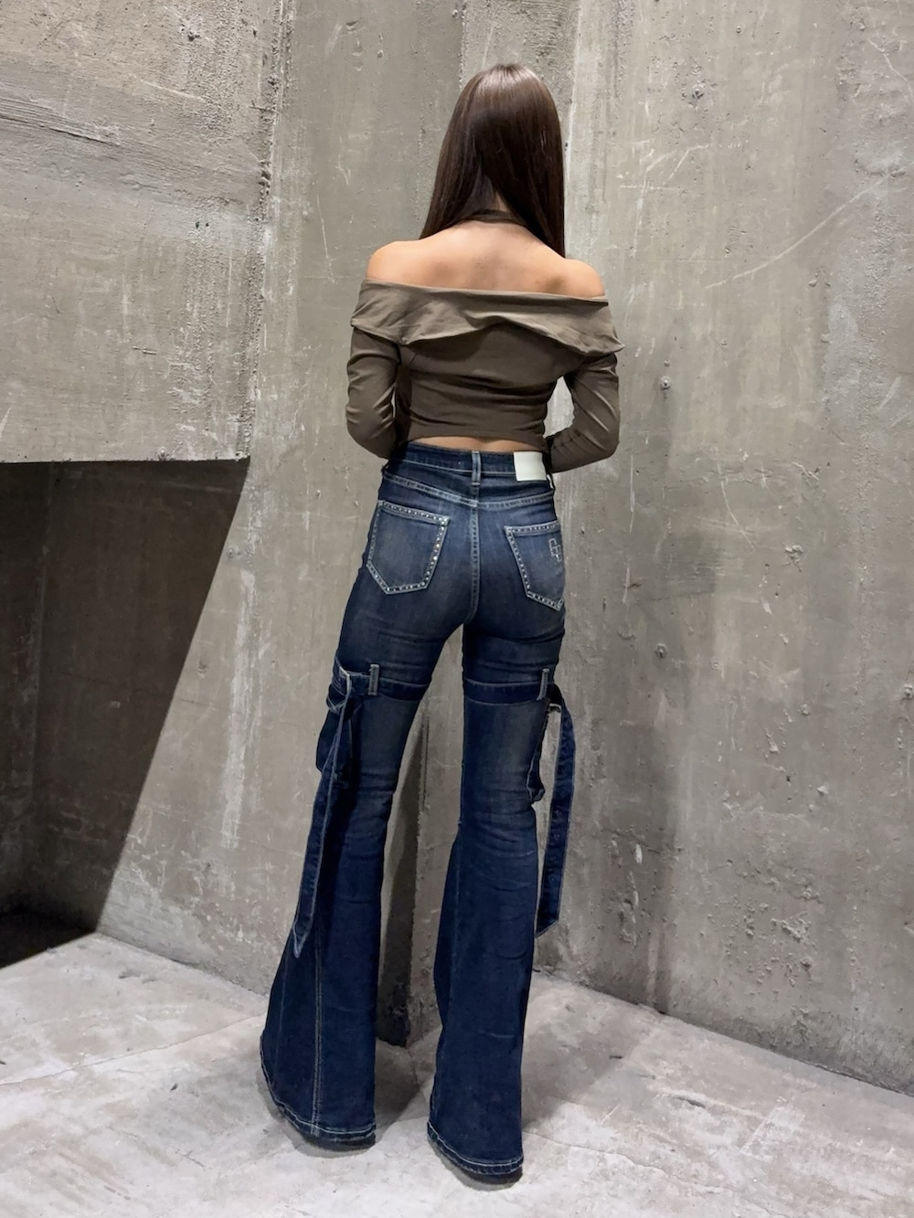 ブルー系のデニムパンツ、ブラック系のブーツ、グリーン系のTシャツ/カットソーを着用したレディースの夏コーディネートの3枚目の写真