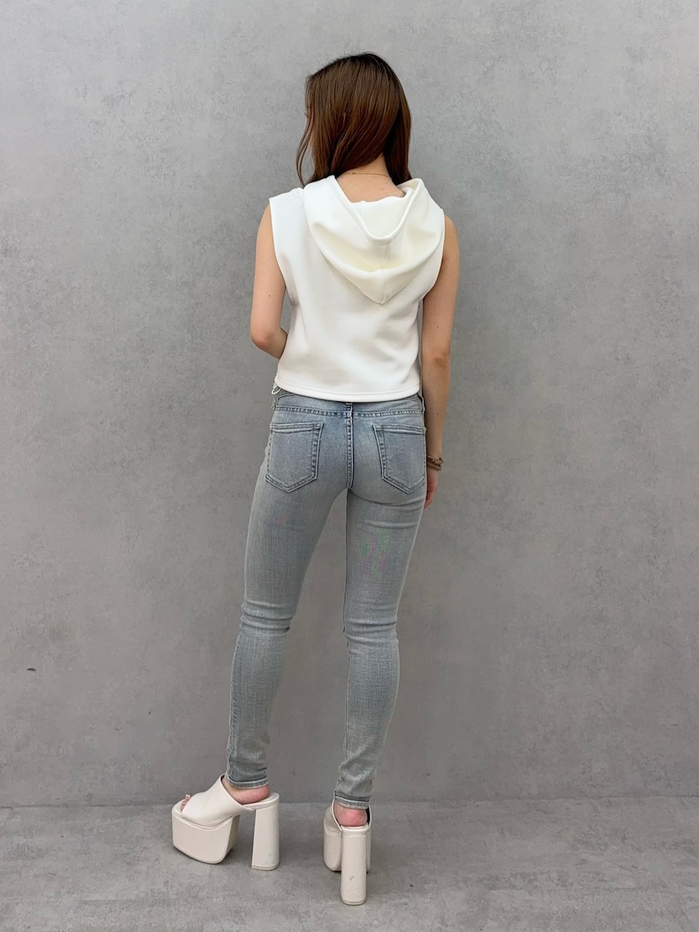 ホワイト系のパーカー、ブルー系のデニムパンツ、ホワイト系のサンダルを着用したレディースの夏コーディネートの3枚目の写真