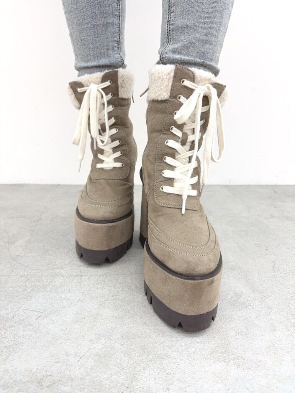 ブルー系のデニムパンツ、ベージュ系のブーツ、ホワイト系のニット/セーターを着用したレディースの秋コーディネートの5枚目の写真