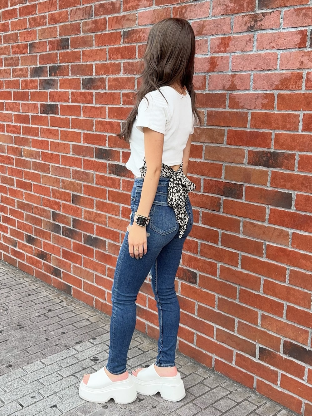 ホワイト系のTシャツ/カットソー、ブルー系のデニムパンツ、ホワイト系のサンダルを着用したレディースの夏コーディネートの2枚目の写真