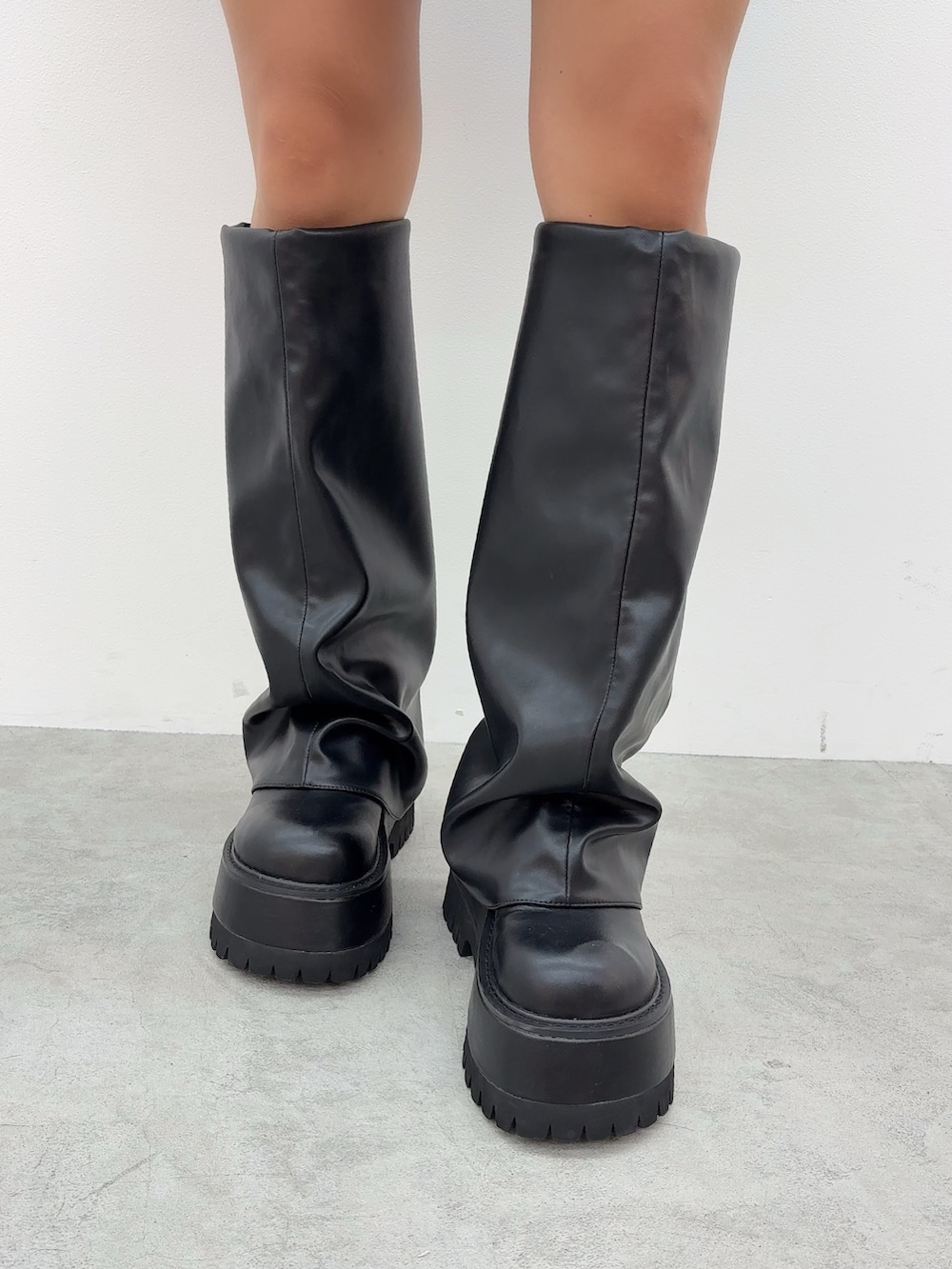 ブラウン系のスウェット、その他のデニムスカート、ブラック系のブーツを着用したレディースの秋コーディネートの6枚目の写真