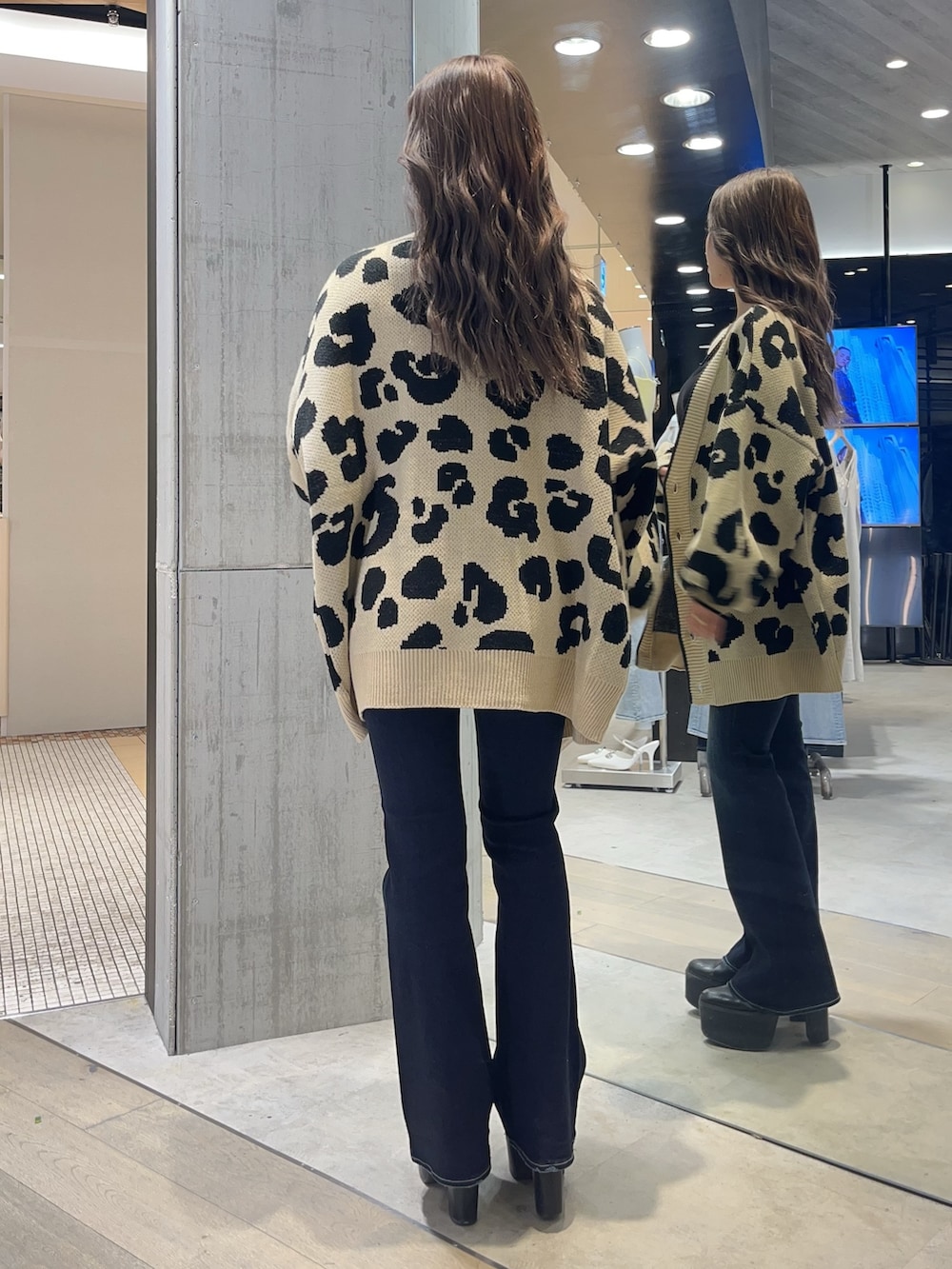 ブラック系のキャミソール、ブルー系のデニムパンツ、ブラック系のブーツを着用したレディースの春コーディネートの3枚目の写真