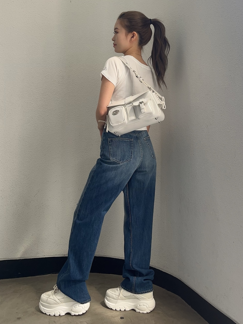 ホワイト系のTシャツ/カットソー、ホワイト系のハンドバッグ、ブルー系のデニムパンツを着用したレディースの春コーディネートの2枚目の写真