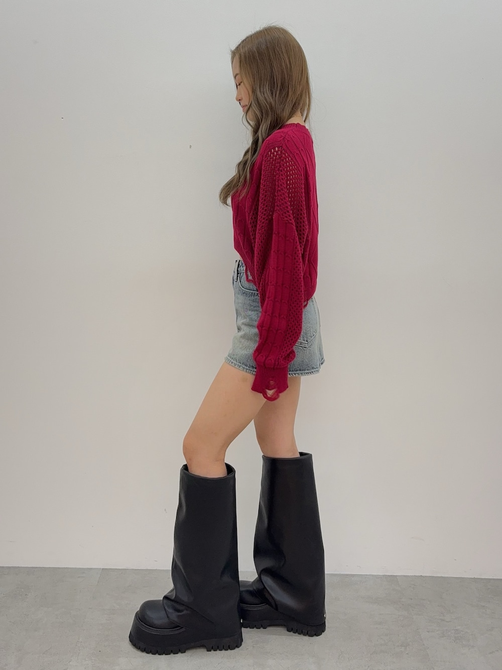 ブラック系のブーツ、ブルー系のデニムスカート、レッド系のニット/セーターを着用したレディースの夏コーディネートの2枚目の写真