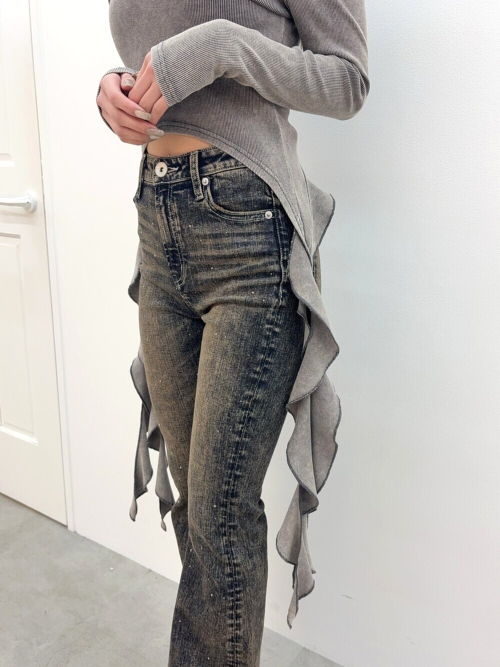 ブラック系のブーツ、ブルー系のデニムパンツ、グレー系のTシャツ/カットソーを着用したレディースの春コーディネートの5枚目の写真