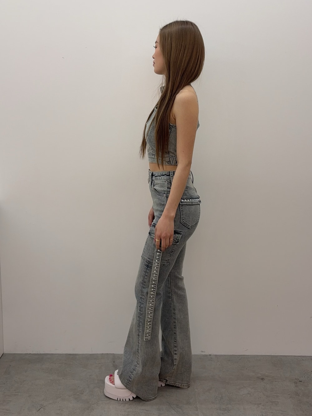 ブルー系のタンクトップ、ブルー系のデニムパンツ、ホワイト系のサンダルを着用したレディースの春コーディネートの2枚目の写真