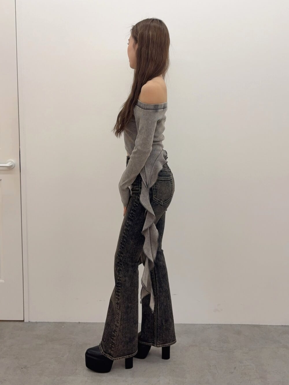 ブラック系のブーツ、ブルー系のデニムパンツ、グレー系のTシャツ/カットソーを着用したレディースの春コーディネートの2枚目の写真