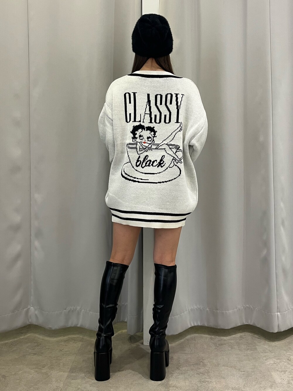 ホワイト系のニット/セーター、ブラック系のブーツ、ブラック系のニットキャップ/ビーニーを着用したレディースの秋コーディネートの3枚目の写真
