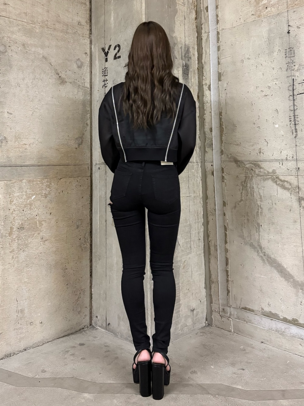 ブラック系のブルゾン、ブルー系のキャミソール、ブラック系のデニムパンツを着用したレディースの春コーディネートの3枚目の写真