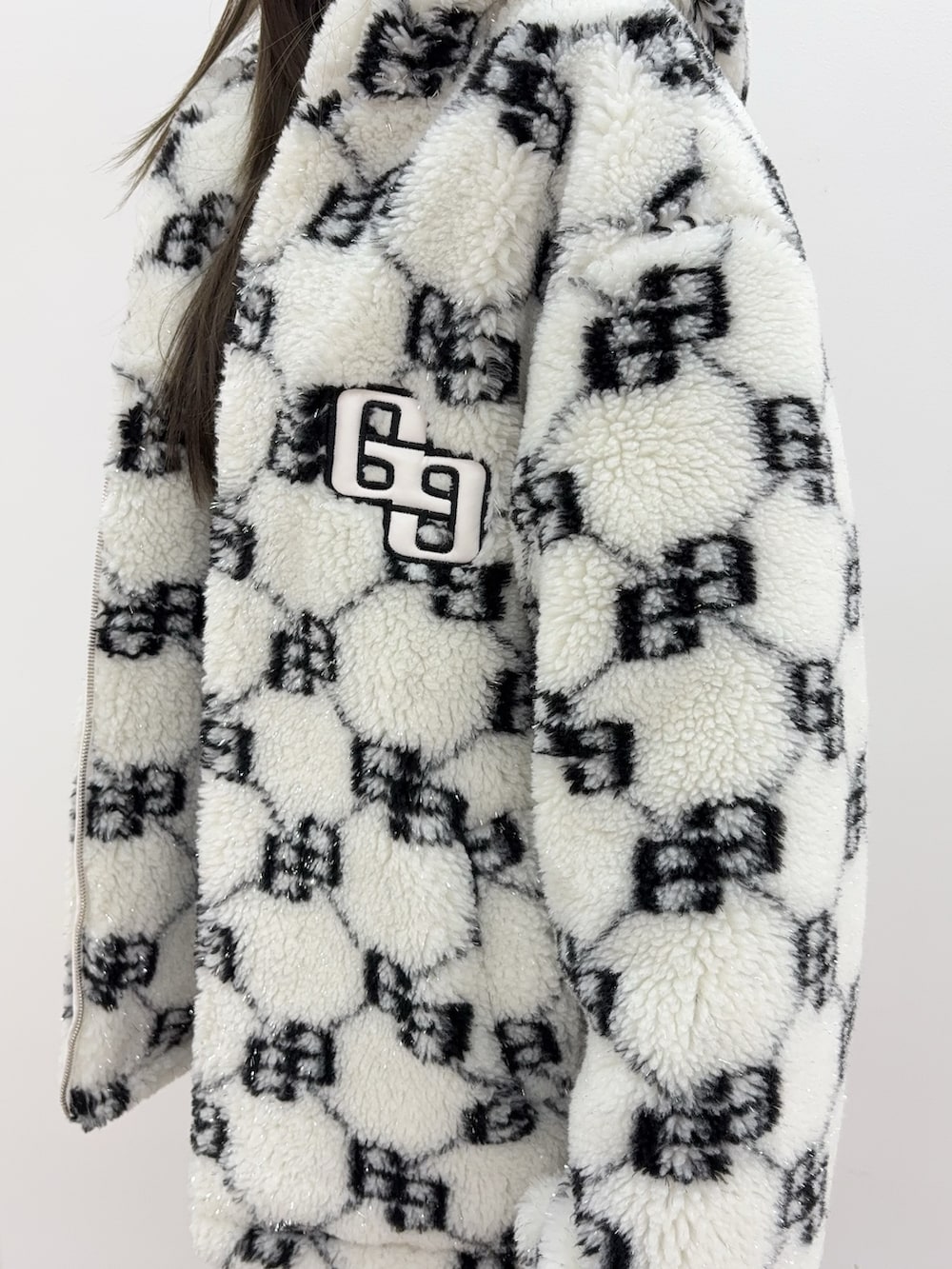 ブラック系のニット/セーター、ブルー系のデニムスカート、ブラック系のブーツを着用したレディースの秋コーディネートの4枚目の写真